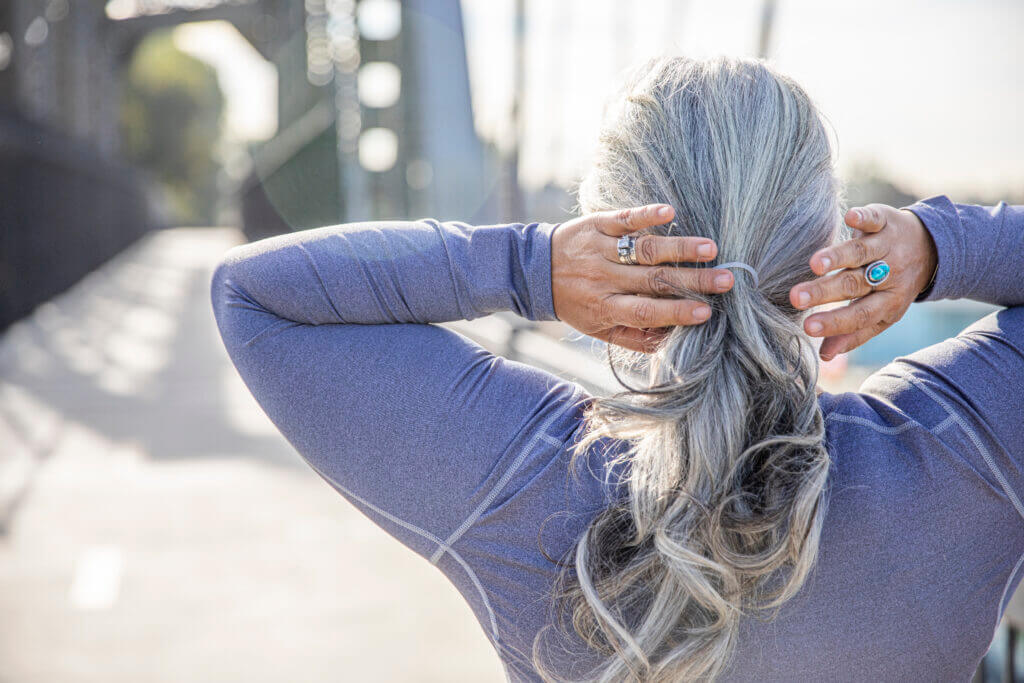 A senior woman fixing her gray hair