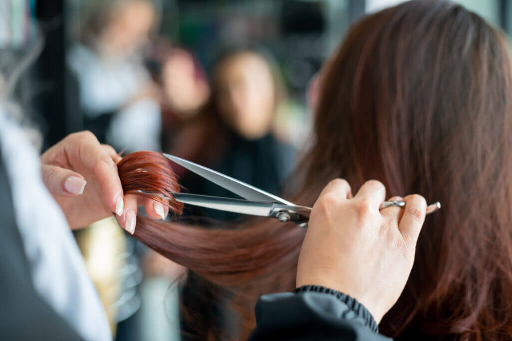 Close up of hairdresser cutting a female customer's hair 