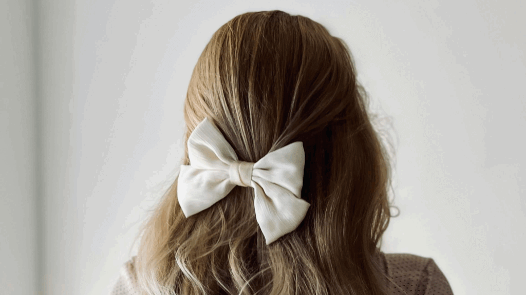 Woman wearing a furry white dress with pearl accessories in her hair