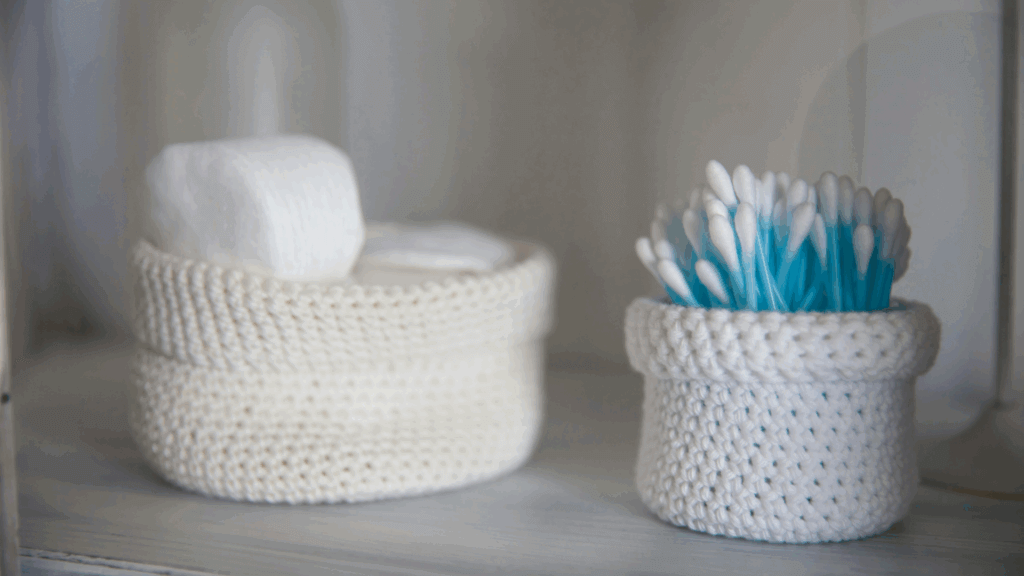 Ceramic bowl holding cotton swabs on a bathroom counter
