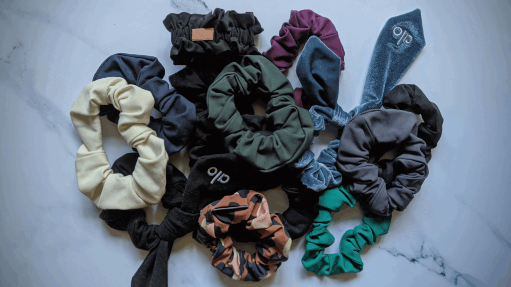 Blue denim jeans with a black and green silk scrunchie placed on top