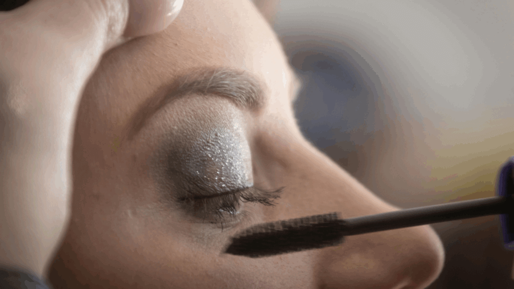 Makeup artist applying mascara on a woman's lashes