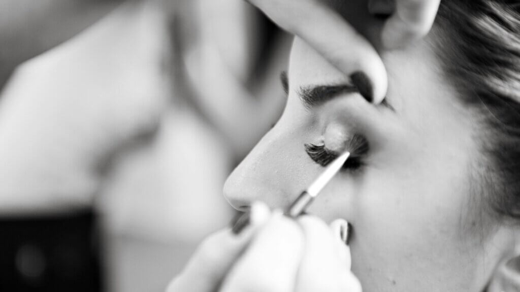 Open black lipstick and makeup scattered on a surface