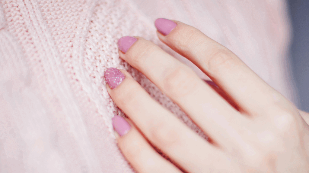 Woman with pink manicure holding her hands together