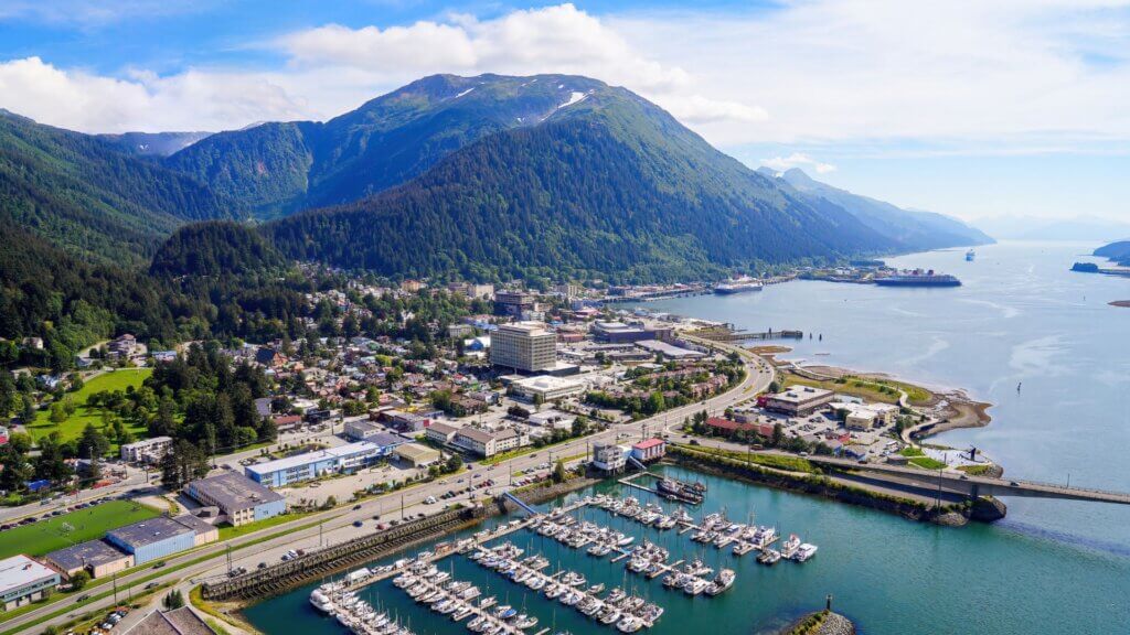 Aerial view of the downtown Juneau, the state capital of Alaska, USA, along the Gastineau Channel in the Arctic - Harris Harbor towered by Alaskan summits next to Douglas Bridge