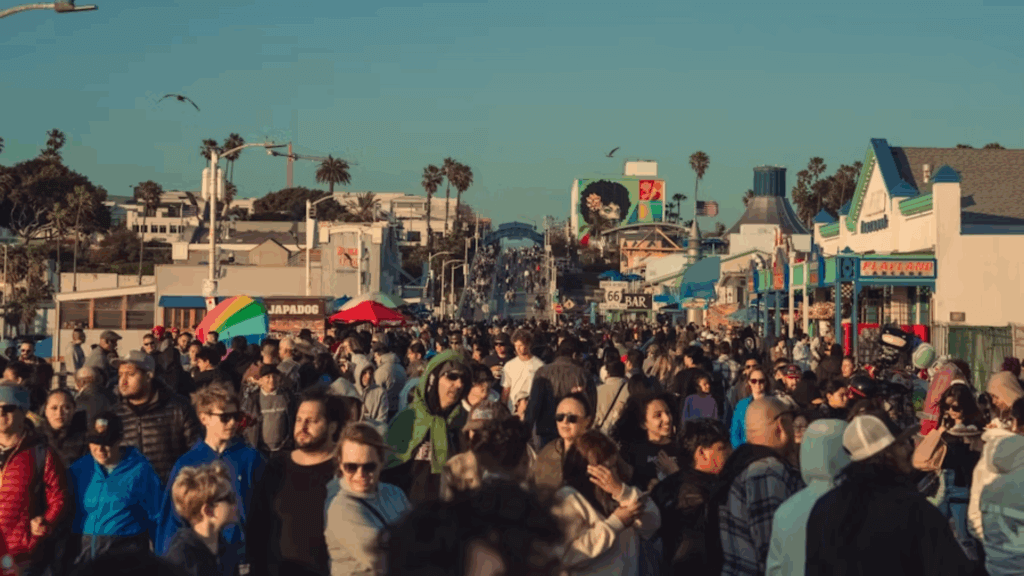 A large crowd walking along a boardwalk
