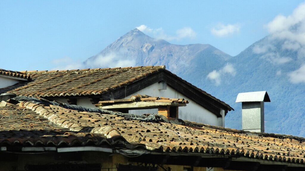 A village with a volcano looming in the background