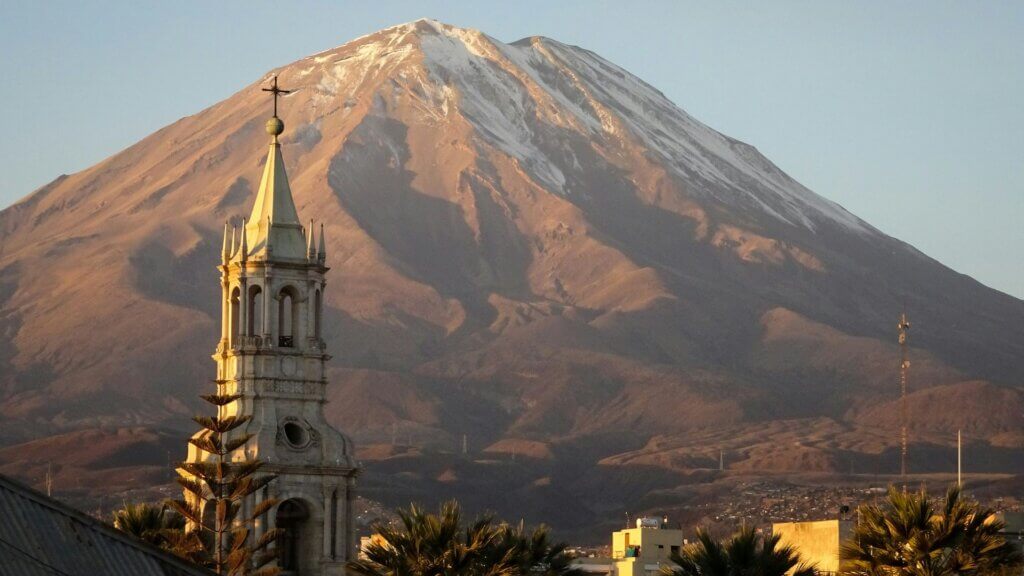 A church with a volcano in the background