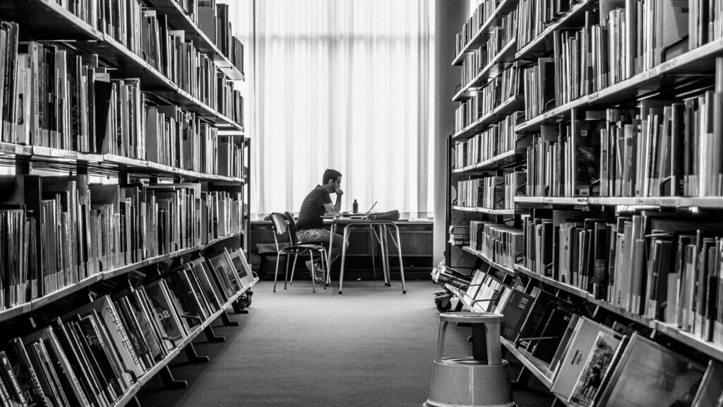 A man sitting at a table in a library