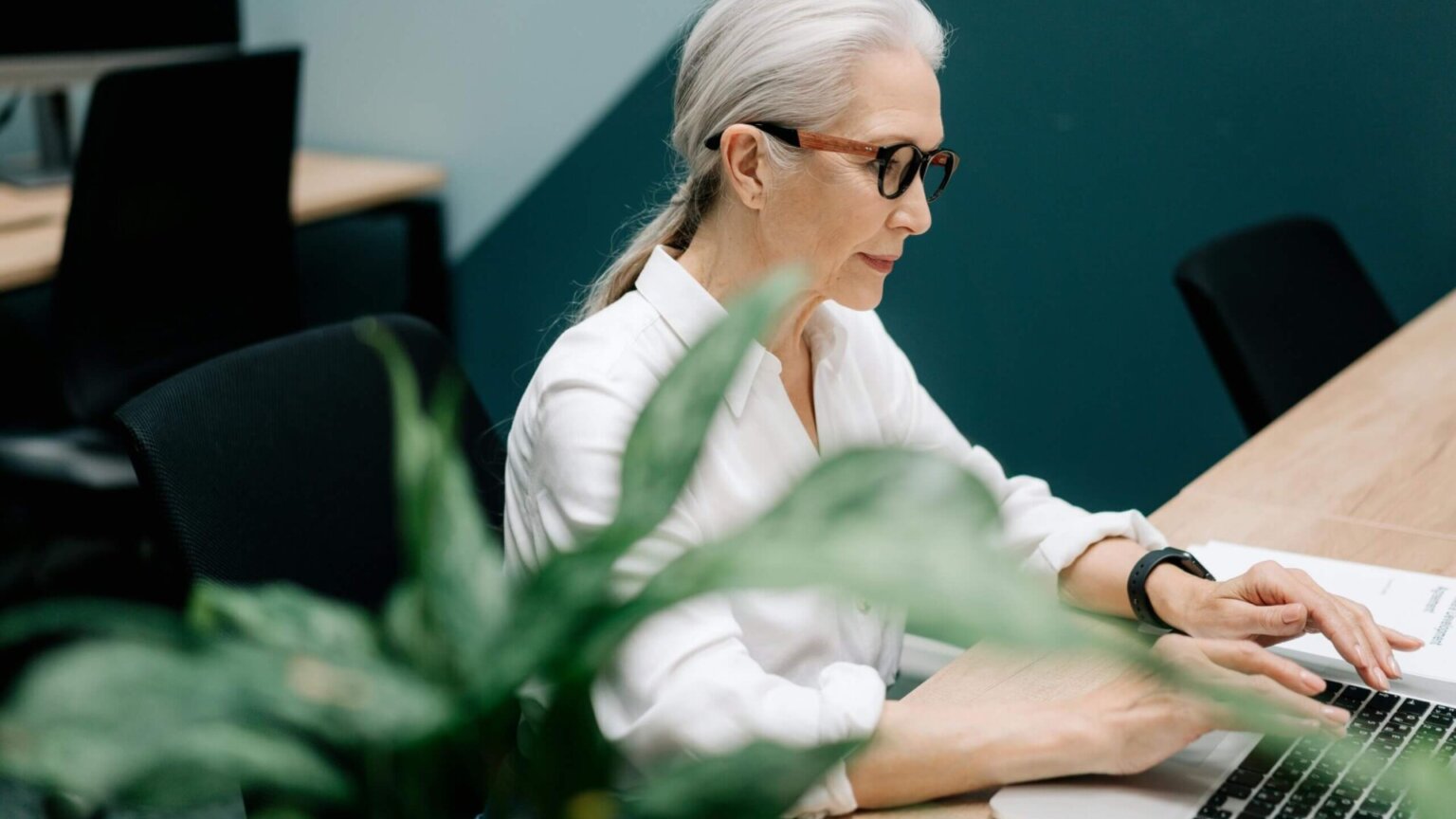 Woman working on a laptop inside a modern office.