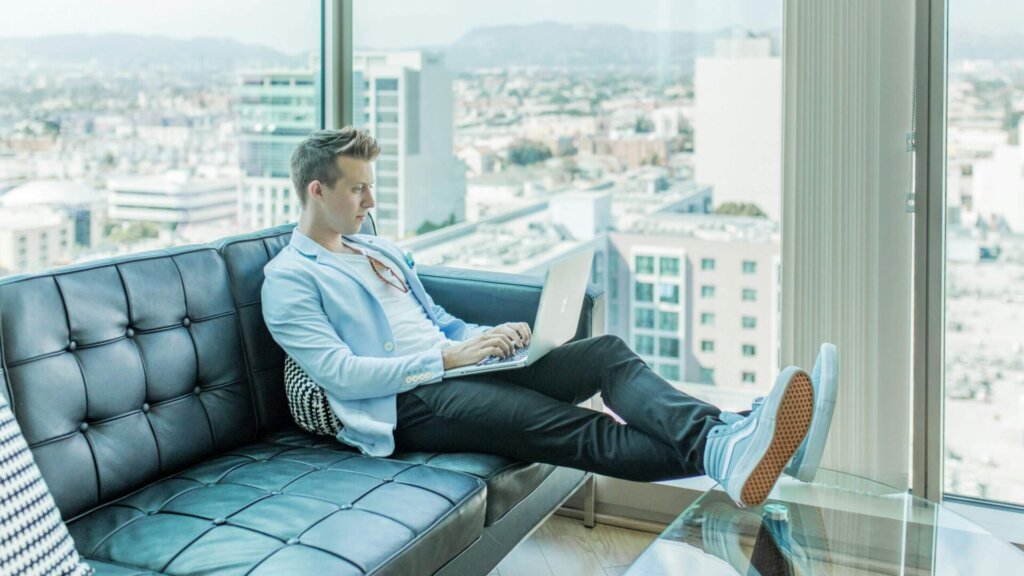 Man sitting on a sofa using a laptop computer.