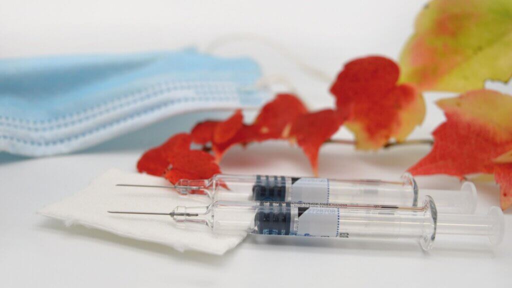 Two shots sitting on top of a paper towel, in front of a mask