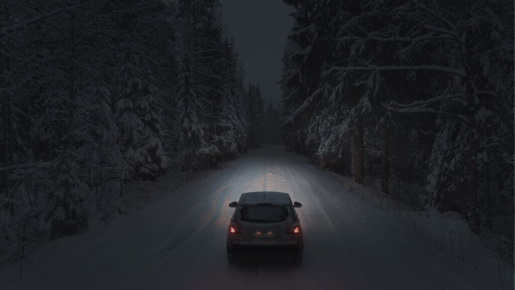 A car driving down a snow-covered road