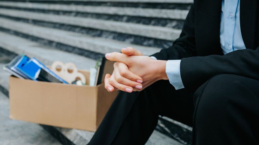 A man sitting on stairs with a box of desk supplies