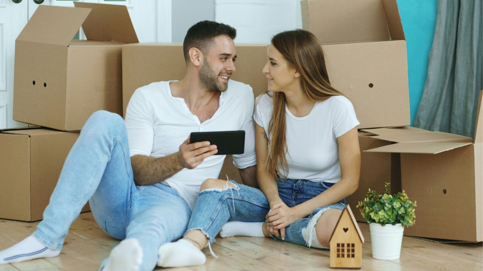 Young couple surrounded by moving boxes in their new home