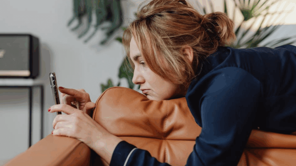 woman looking at phone unhappy