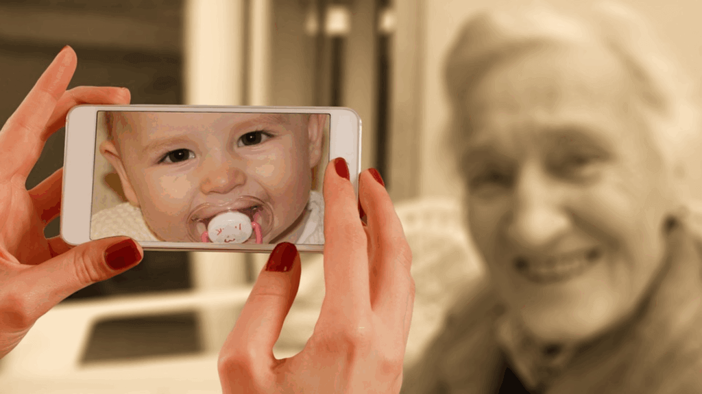 Hand taking a photo of an old lady but phone is showing a baby photo