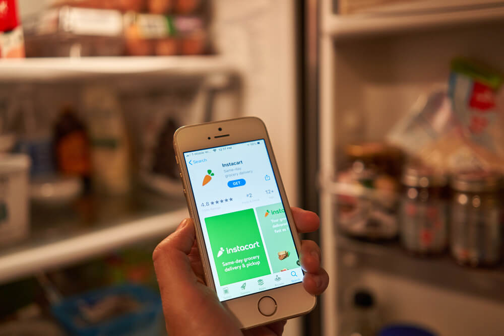 Person holding a phone with the Instacart app