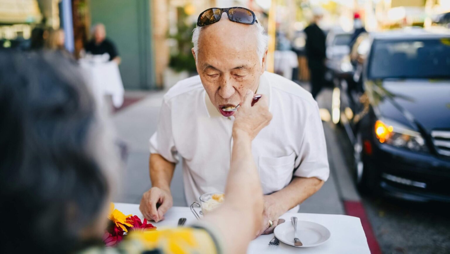 Man in a white polo shirt with black sunglasses resting on his head.