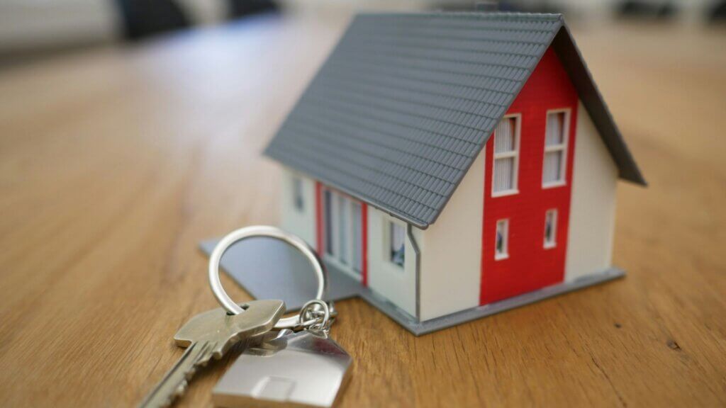 Small red and white model house sitting on a wooden table
