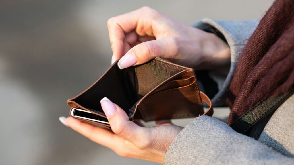 Person holding a smartphone while reviewing financial information