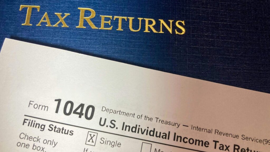 Tax return documents and financial paperwork spread across a desk.