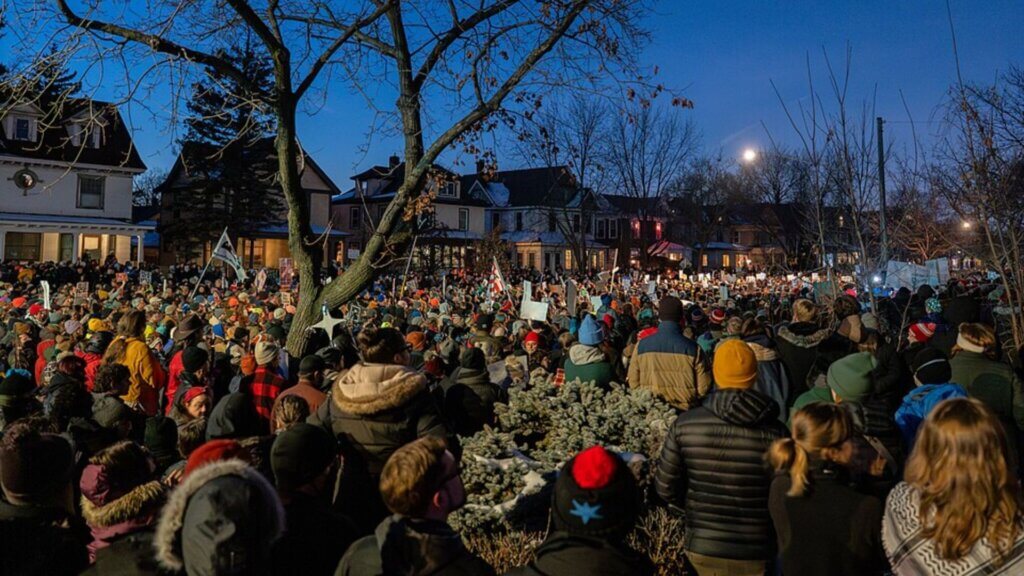 Thousands of people gather at a candlelight vigil and protest in Minneapolis to mourn Renee Nicole Good, holding signs and candles in the streets as part of citizen activism in American politics.