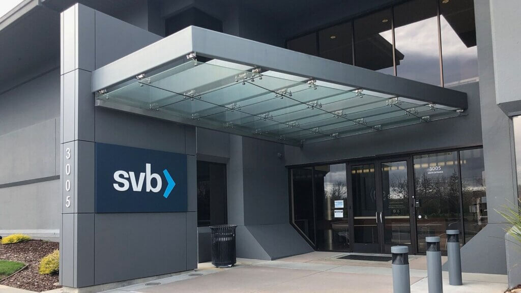 Exterior of a Silicon Valley Bank (SVB) branch showing modern gray walls and glass awning.