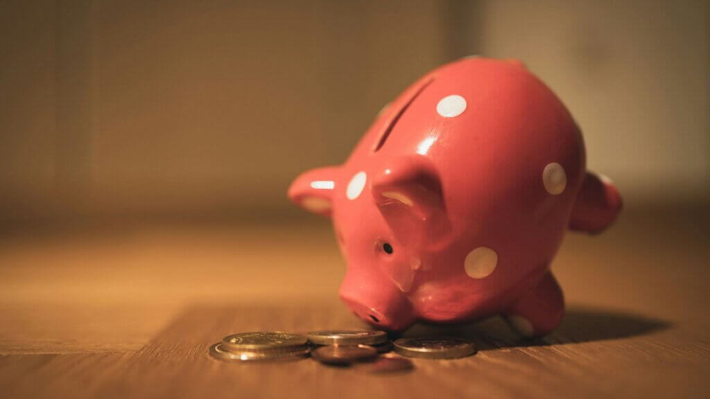 Pink piggy bank sitting on a wooden table representing personal savings