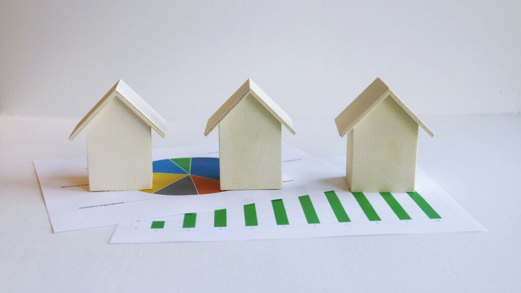 Three miniature houses placed on top of official paperwork