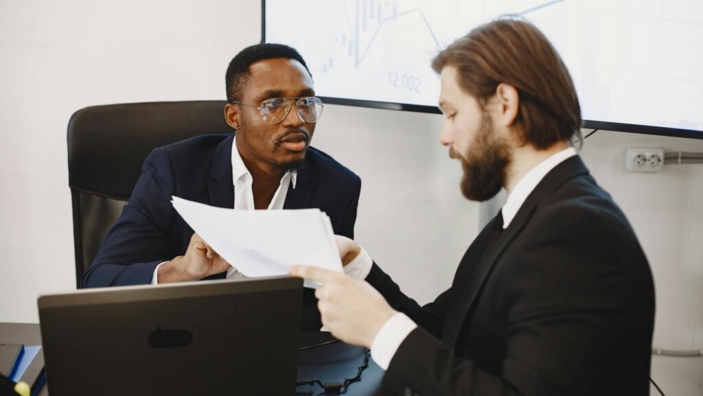 Business professionals reviewing printed documents during a meeting.