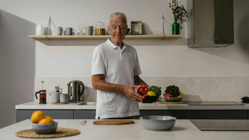 Man in a white polo shirt holding a bowl of mixed vegetables.
