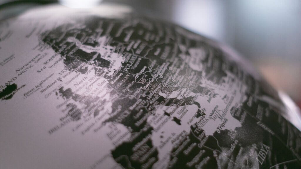 Black and white image of a globe sitting on a desk