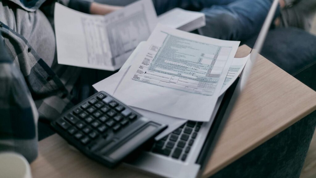 Stack of blank white printer paper placed on a wooden table.