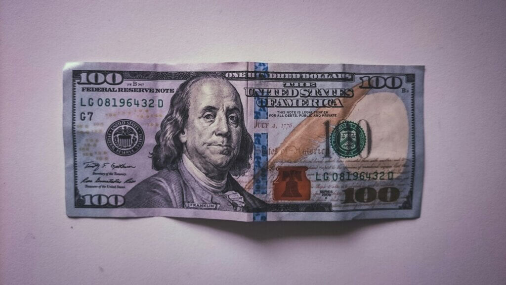 Folded $100 bill showing signs of handling and creasing