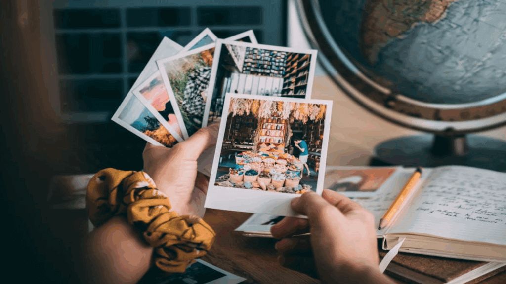 person holding old polaroid photos