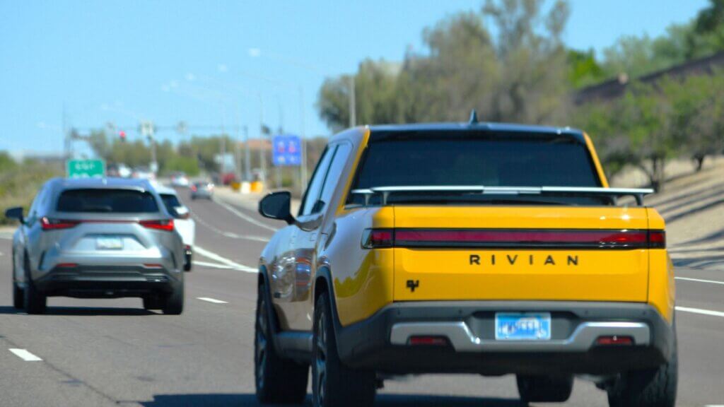 Yellow Rivian truck on freeway