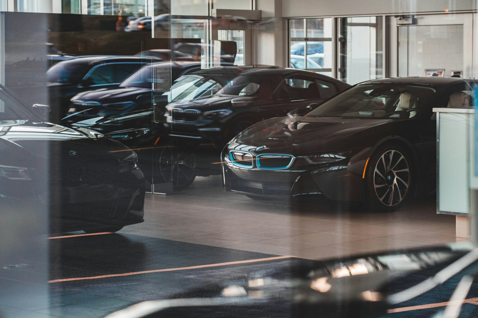 Cars on display behind store glass window