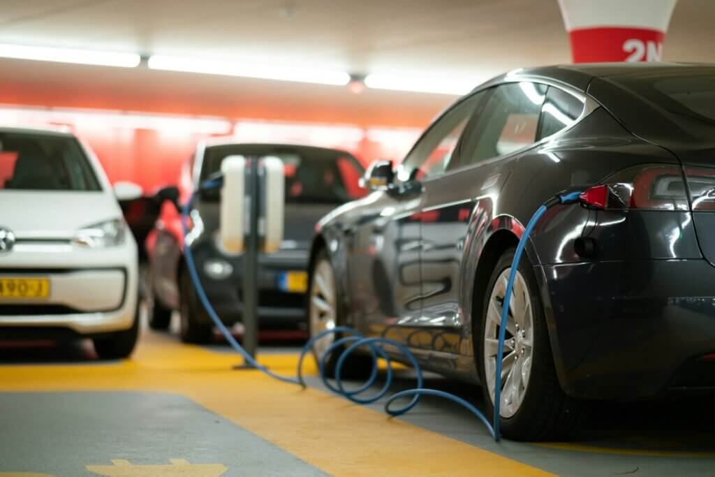 Black EV car charging in a parking lot