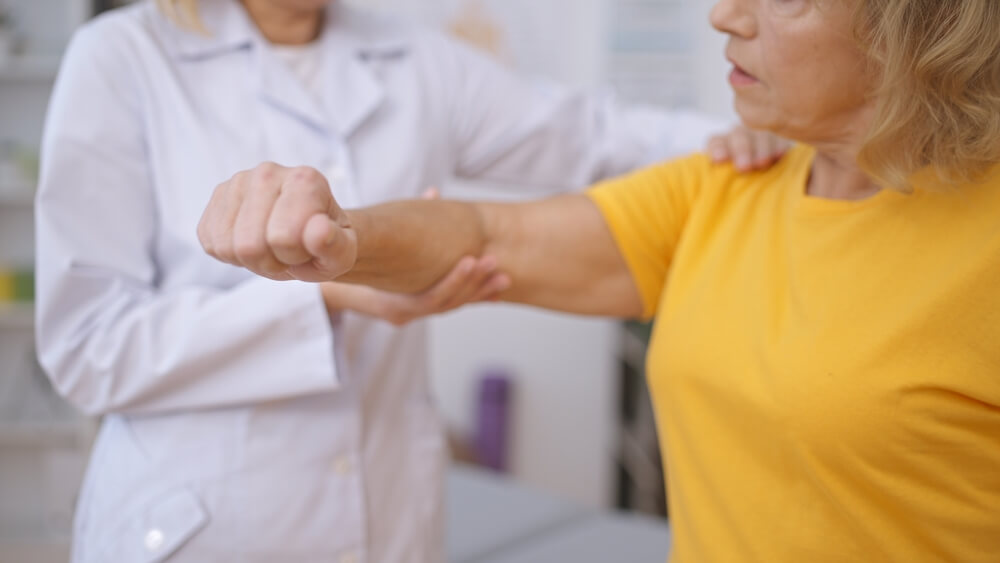 Therapist assessing a senior patient's arm
