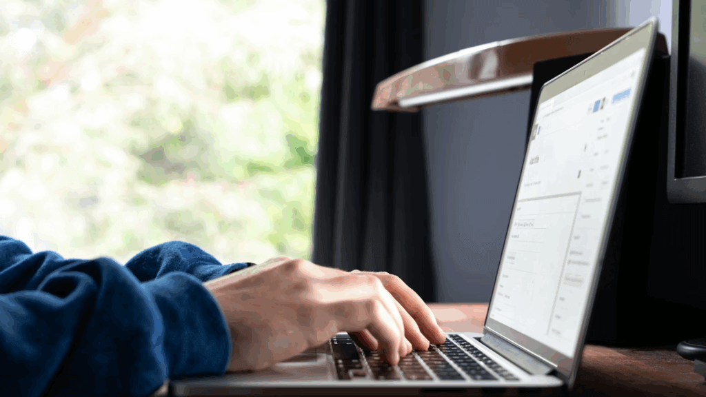 person typing on their laptop