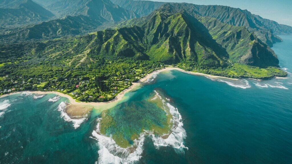 Aerial view of green and brown mountains surrounding a lake