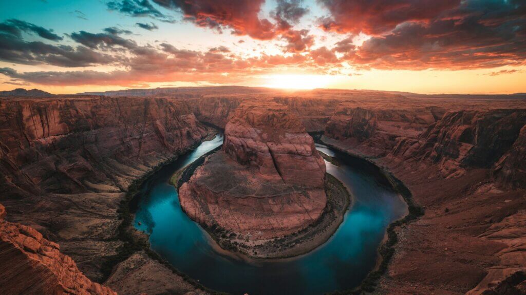 Desert mountains and winding river at sunset.