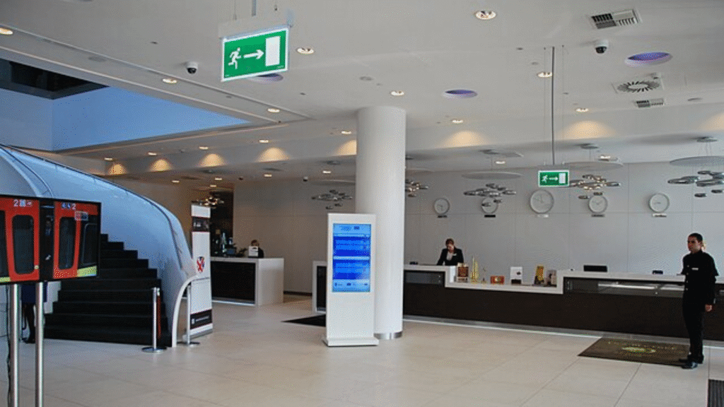 Modern hotel lobby with reception desk and staff behind the counter.