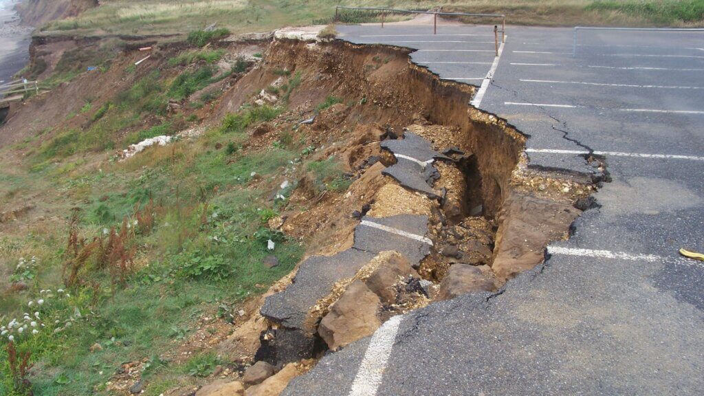 Wide crack running through asphalt road surface