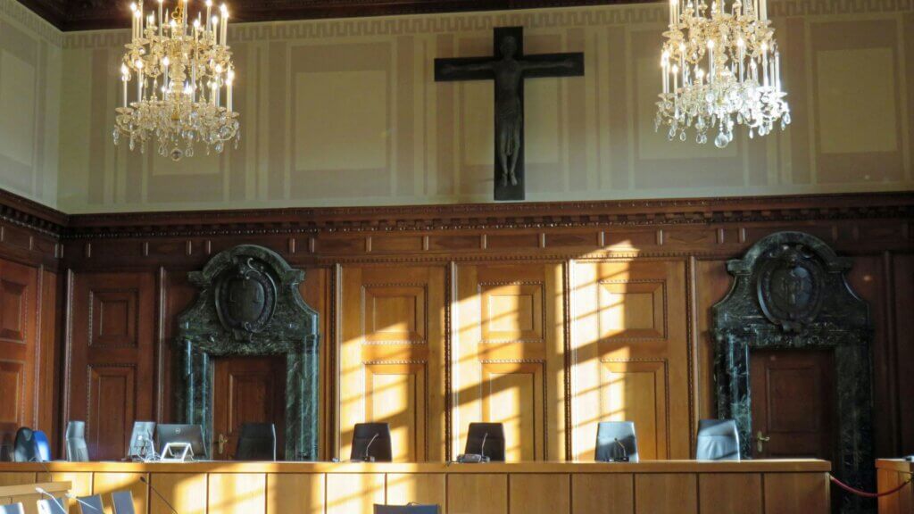 Empty courtroom with wooden benches and judge’s bench in view