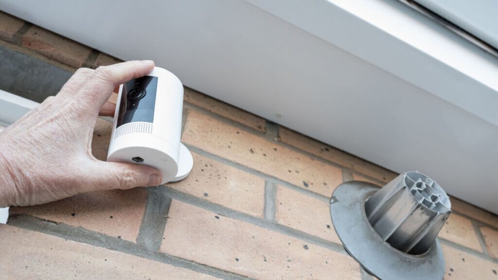 Homeowner installing a wireless smart CCTV security camera