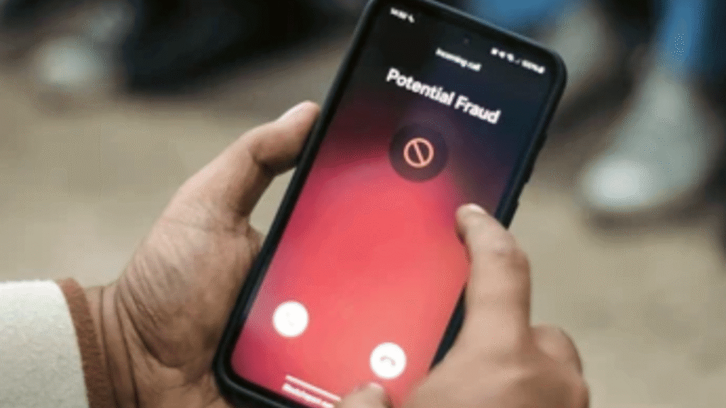 Person holding a smartphone showing a “Potential Fraud” call warning.