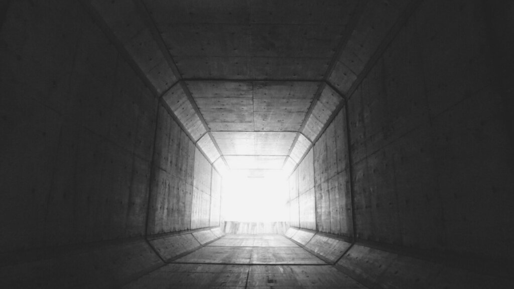 A strong beam of light coming from the end of the tunnel.