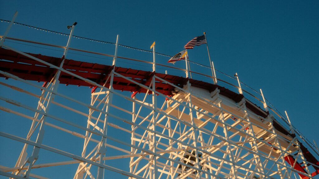Empty roller coaster structure with a national flag displayed at the top